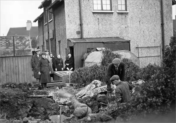 People of James Reckitt Avenue, Hull, Yorkshire, look as the men dig the garden