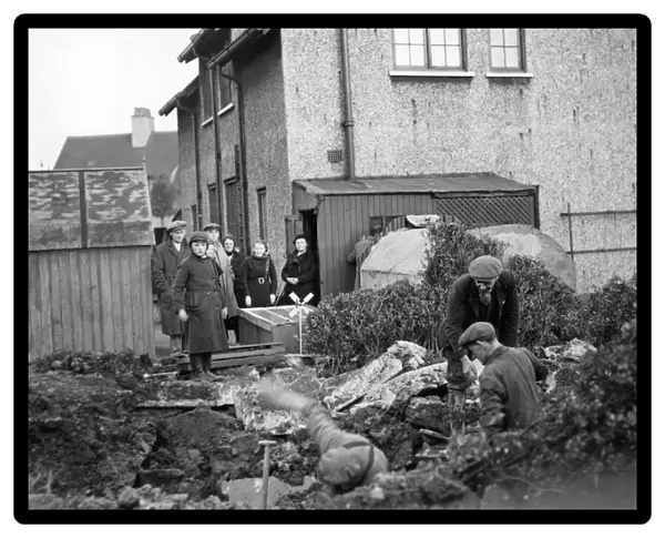 People of James Reckitt Avenue, Hull, Yorkshire, look as the men dig the garden