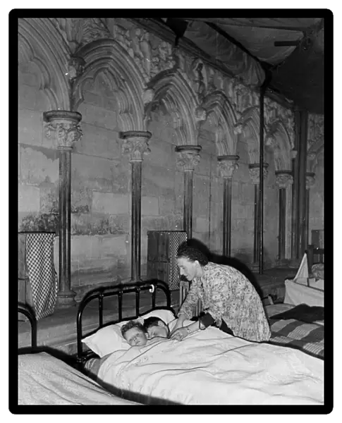 A woman tucking two children into bed, Salisbury Cathedral