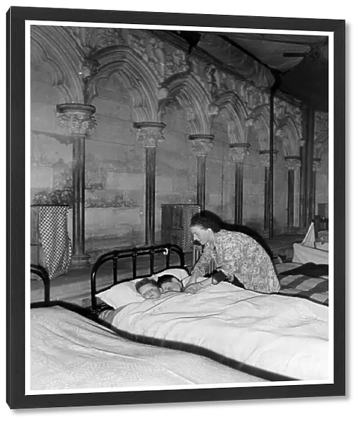 A woman tucking two children into bed, Salisbury Cathedral