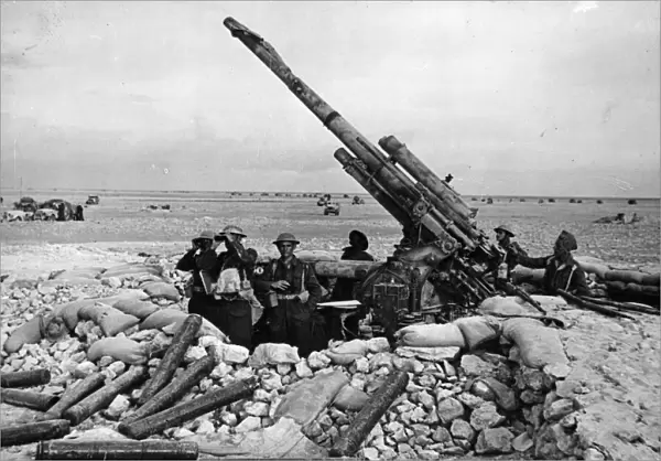 A captured Italian anti-aircraft gun, the pit of which is being used as an observation