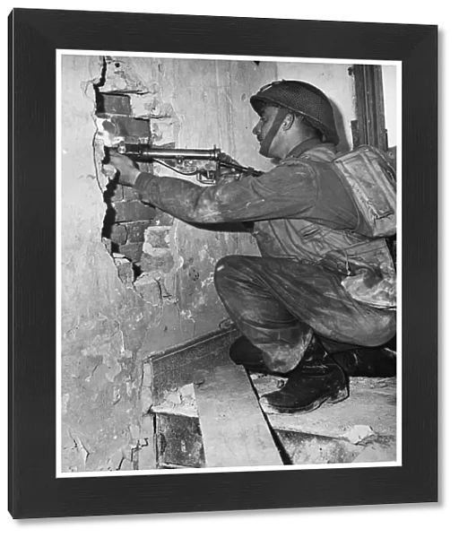 Canadian soldier Corporal Andy Mouflier from Winnipeg, fires a peephole in the wall of a