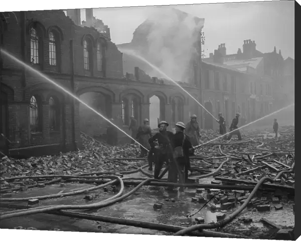 Firemen dampening down fires in Moseley Street, Birmingham the morning after a heavy
