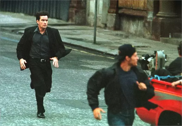 ACTOR CHARLIE SHEEN FILMING IN GLASGOW JULY 1997 IS SEEN RUNNING BEHIND A MOVING