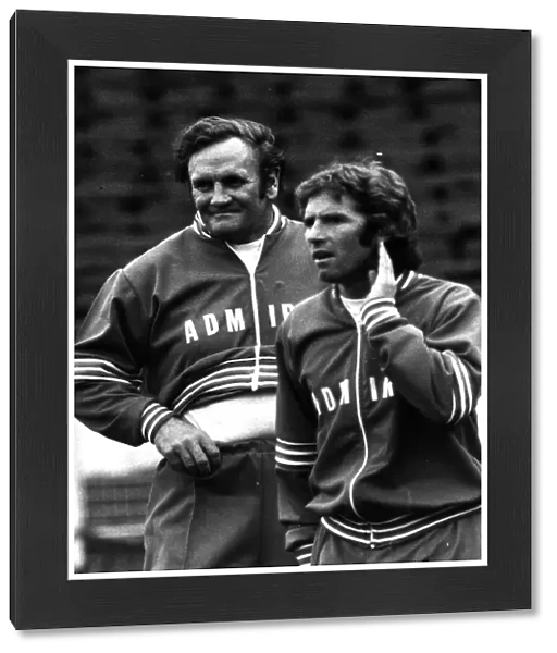 Football manager Don Revie with Alan Ball hand to ear wearing a track suit 1977