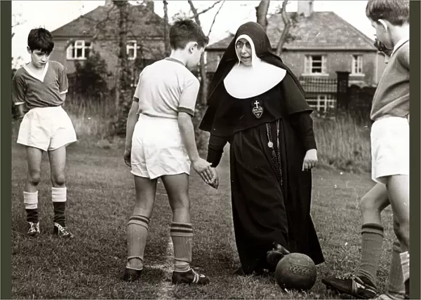 Sister Gabriel explains the art of trapping the ball to a young footballer of the St