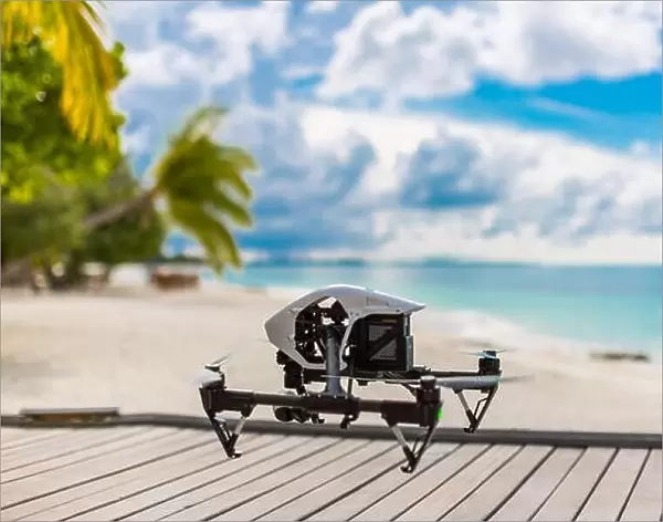 Flying drone with mounted camera at the beach. Palm trees and blue lagoon