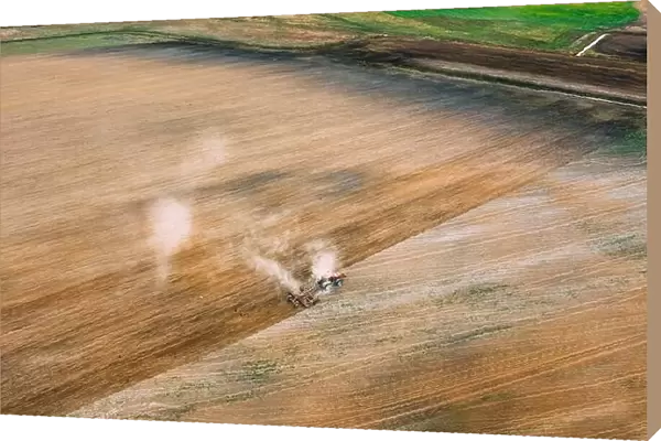 Aerial View. Tractor Plowing Field In Spring Season. Beginning Of Agricultural Spring Season. Cultivator Pulled By A Tractor In Countryside Rural Fiel