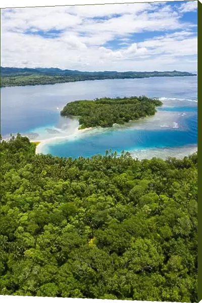 A coral reef surrounds idyllic, tropical islands off the coast of New Britain in Papua New Guinea. This area is part of the Coral Triangle