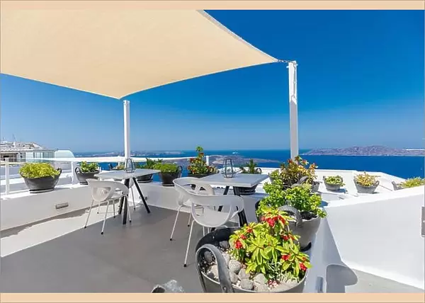 Beautiful Santorini terrace landscape, white architecture with sunny caldera view. Famous tourist hotel resort, travel vacation destination