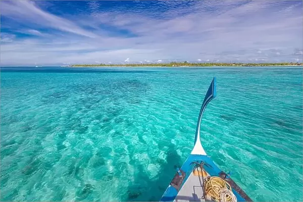 Traditional Maldivian boat Dhoni with amazing tropical island background view. Nature paradise beach, open sea view, seascape in Maldives, luxury