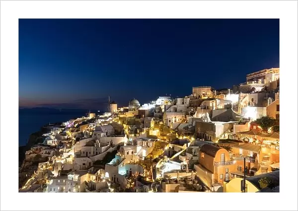 Stunning night view of fabulous caldera view, picturesque village of Oia with traditional white houses under sunset. Amazing travel vacation landscape