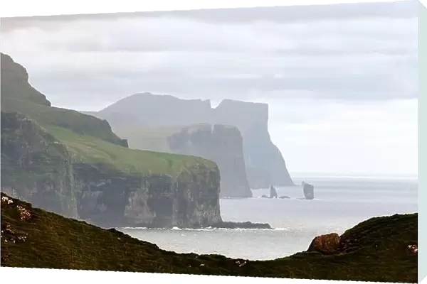 Famous Risin og Kellingin rocks and cliffs of Eysturoy and Streymoy Islands seen from Kalsoy Island. Faroe Islands, Denmark. Landscape photography