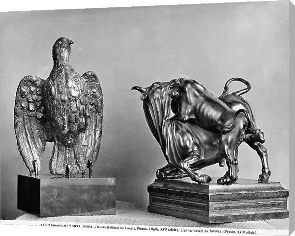 Bronze sculpture representing a pigeon and the fight between a bull and a lion, work preserved in the Louvre Museum, Paris The pigeon has wide open wings. The other sculpture represents the lion knocking down the bull