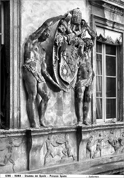 Coat of arms held up by two ephebes, made by Giulio Mazzoni and located between two windows overlooking the courtyard of Palazzo Spada, Rome