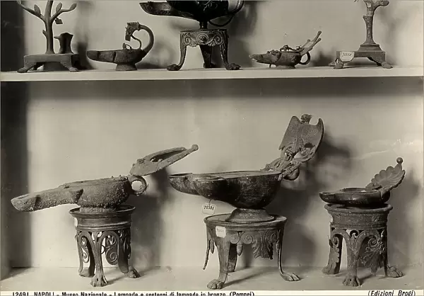 Two shelves with lamps and bronze bases in various shapes and sizes. Found in Pompeii and now located in the National Archaeological Museum of Naples
