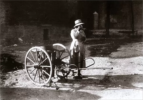 On a street in Rome, a streetsweeper rests next to her cart