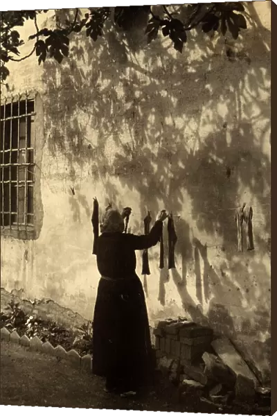 Old lady hanging out the washing. Postcard sent by the photographer to Vincenzo Balocchi