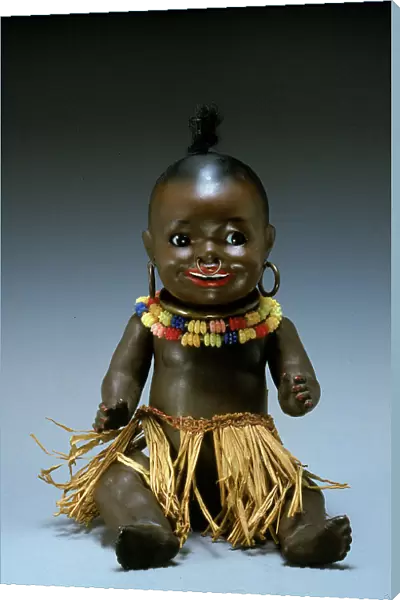 Black baby doll made in Germany in the 1930s. The doll is shown as a small African native with a ring in its nose, a straw skirt and a gaudy necklace and earrings