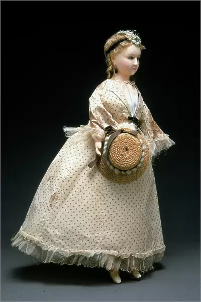 Papier-mach and wax doll made in Germany in the second half of the Nineteenth century, dressed in light summer dress of Romantic style complete with a straw hat
