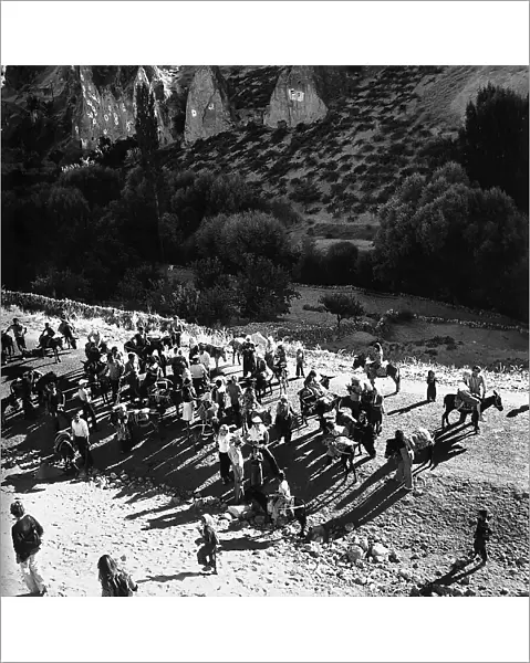 A tourist group arriving on mules to around the burried city of Kaymakli, Turkey