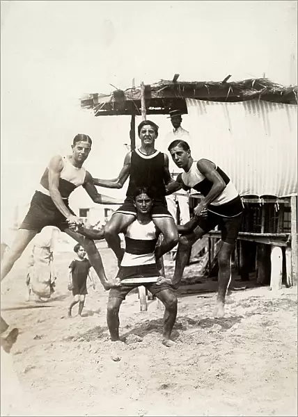 Group of young sports enthusiasts performing acrobatics on the beach of the Bagnni Pancaldi swimming establishment