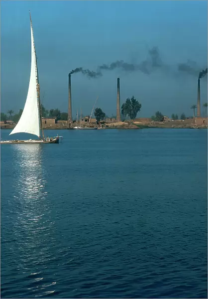 Cairo. The Nile River on the outskirts of the city in the industrial area, with a boat