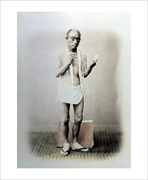 Full-length portrait of a japanese painter. The artist is posing in scanty summer clothes, made up of a loincloth and a singular vest with wide stitching. On his feet, short white socks and thong sandals