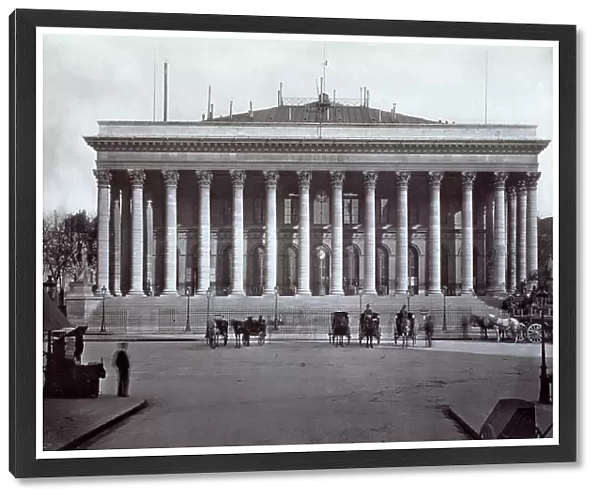 The classicizing building of the bourse in Paris, surrounded by tall columns on the square of the same name in front. A few carriages are waiting