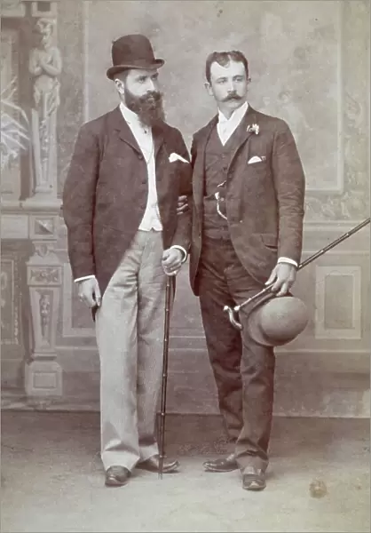 Full-length portrait of two men in elegant clothing with hat and cane