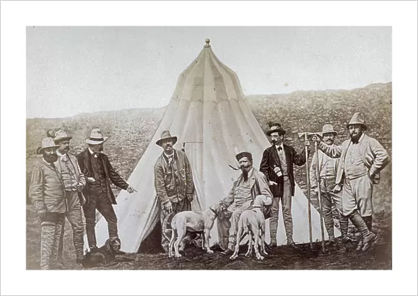 Portrait of King Victor Emmanuel II with Marquis Lovera and other men in a hunt. Victor Emmanuel is seated and petting the dogs before his tent