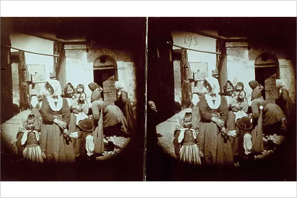 Scene of life in a town in Abruzzo, Italy: group of women, in working class clothes, with children