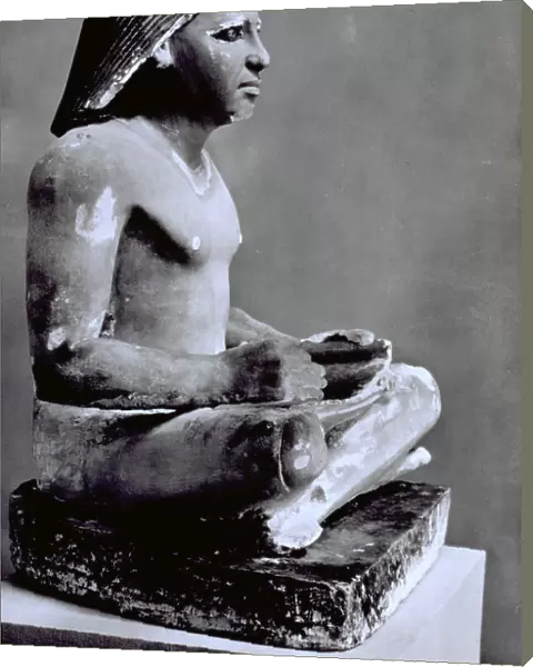 Egyptian statue of a scribe reading a papyrus. The statue dating to 2700 b.c. is in the Egyptian Museum of Cairo