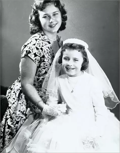 Girl in communion clothing with her older sister
