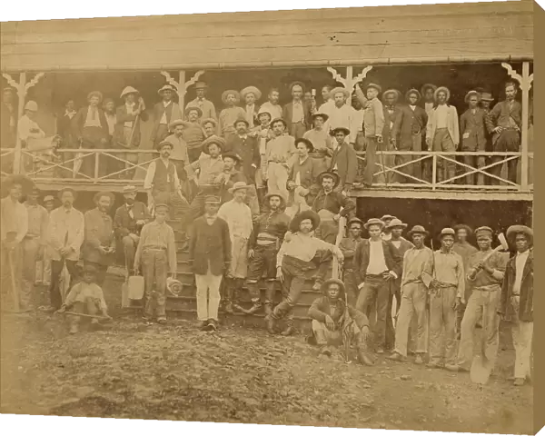 Group of workers from the company that dug the Panama Canal. The group is arranged in various ways: under the porch of a wooden house, on the steps leading to the entrance, at the sides of the steps