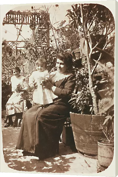 Two women with a child photographed in a terrace; postcard