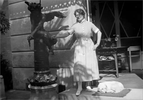 A woman posing with a dog in front of a veranda
