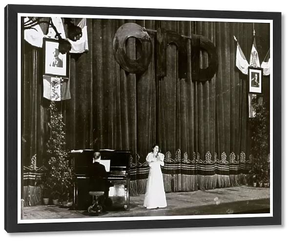 A singer and a pianist on stage during a show organized by the National Recreational Club ('Opera Nazionale Dopolavoro', OND); postcard
