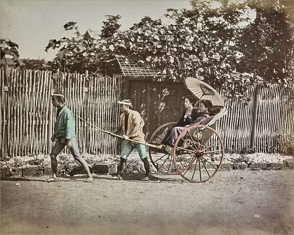 Two men carry two young women on a rickshaw