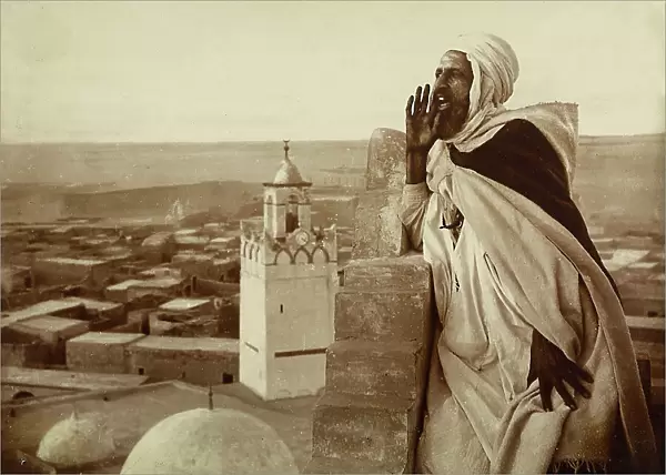 Muezzin recites a prayer from a minaret