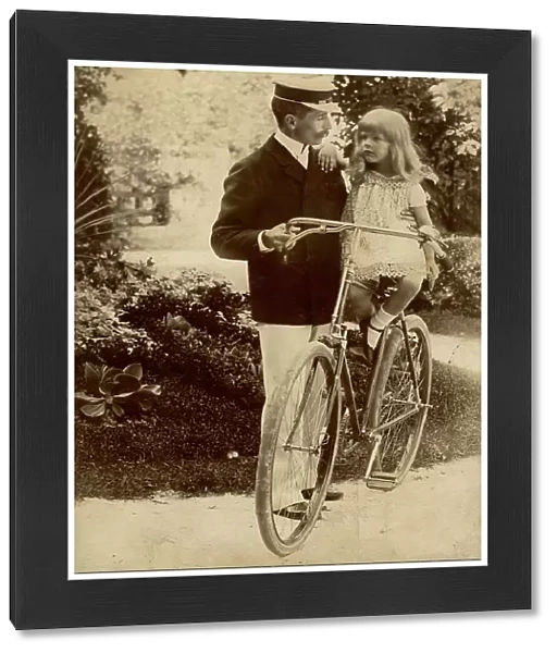 Portrait of a man in uniform holding a baby, maybe her daughter, on a bike