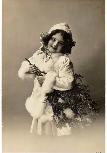 Portrait of a young little girl carrying a fir-branch tree, Christmas greeting post-card, with a personal dedication in german on the back side
