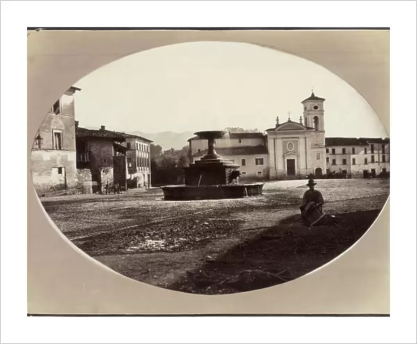 A square in Rieti. In the foreground a fountain and a man seated on the ground. In the background a church