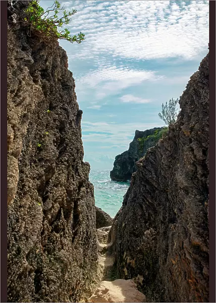 Bermuda, View of beach through narrow gap between rocks