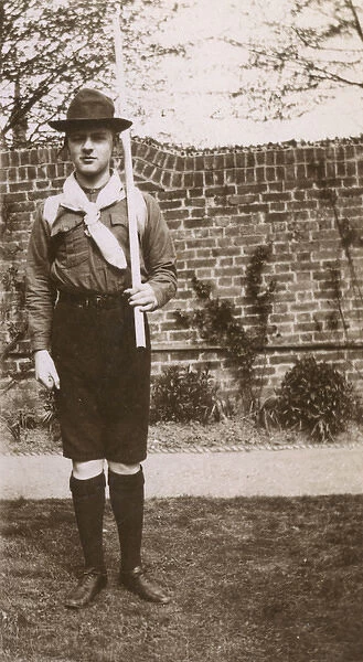 Boy in scout uniform in garden, Ealing, West London