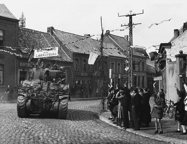 British armour enter Belgium, one of the first tanks passing through the village of