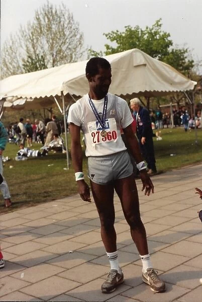 British Caribbean marathon runner standing with medal