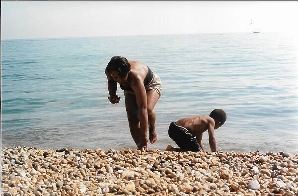 British Caribbean mother and son on Brighton beach gather st