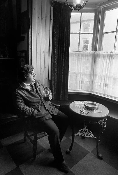 A customer sits with a drink in Browns Hotel, Laugharne