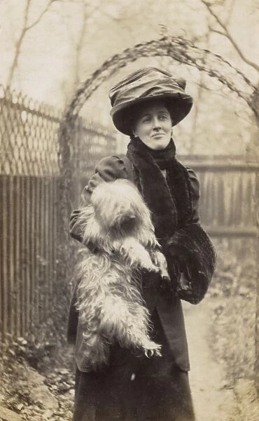 Edwardian woman holding a terrier in a garden